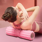 Woman using foam roller for back muscle release and yoga recovery routine