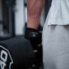 Wrist straps wrapped around pull up bar to support grip and reduce forearm fatigue during upper body workouts