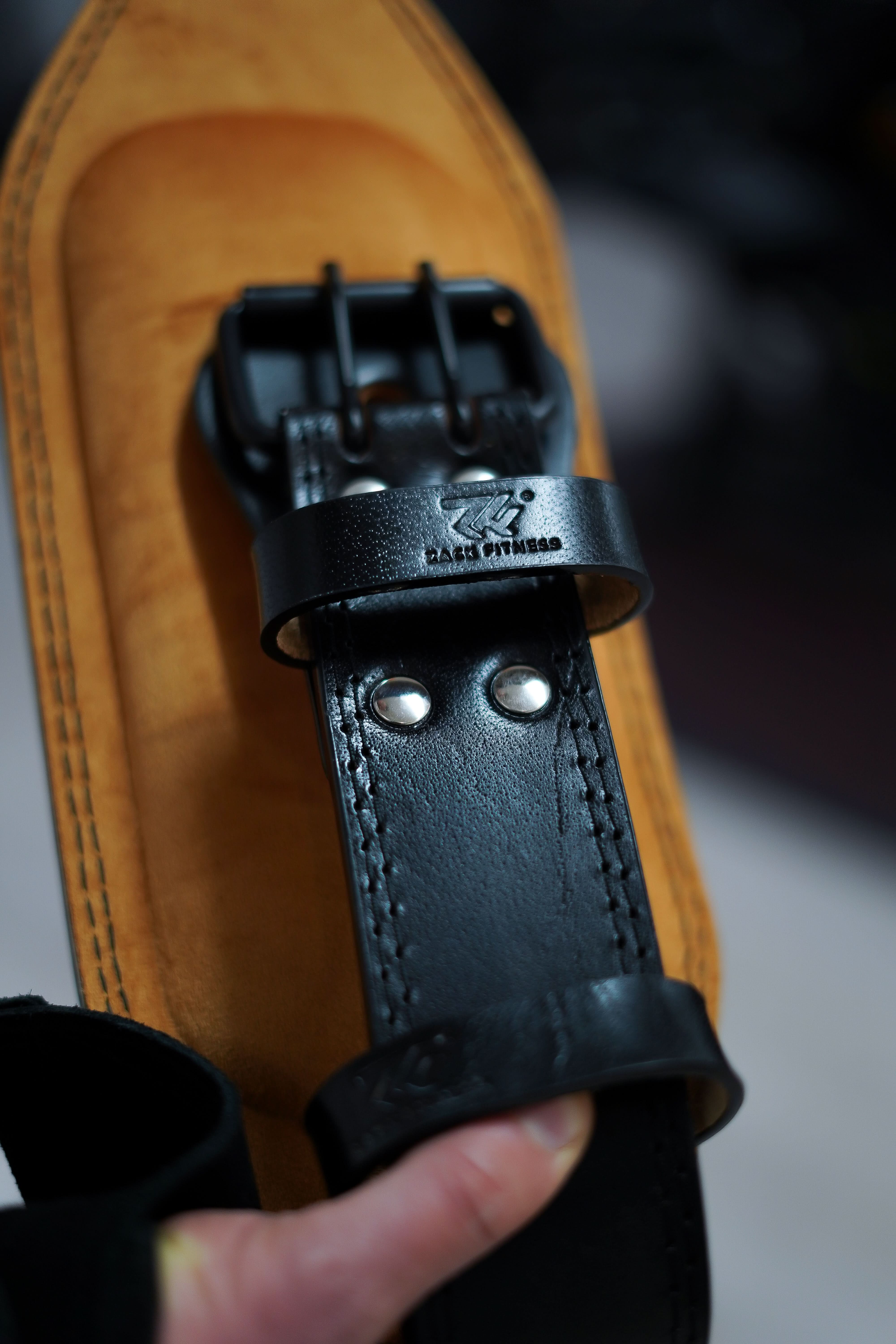 leather weightlifting belt worn during deadlifts providing core and lumbar stability